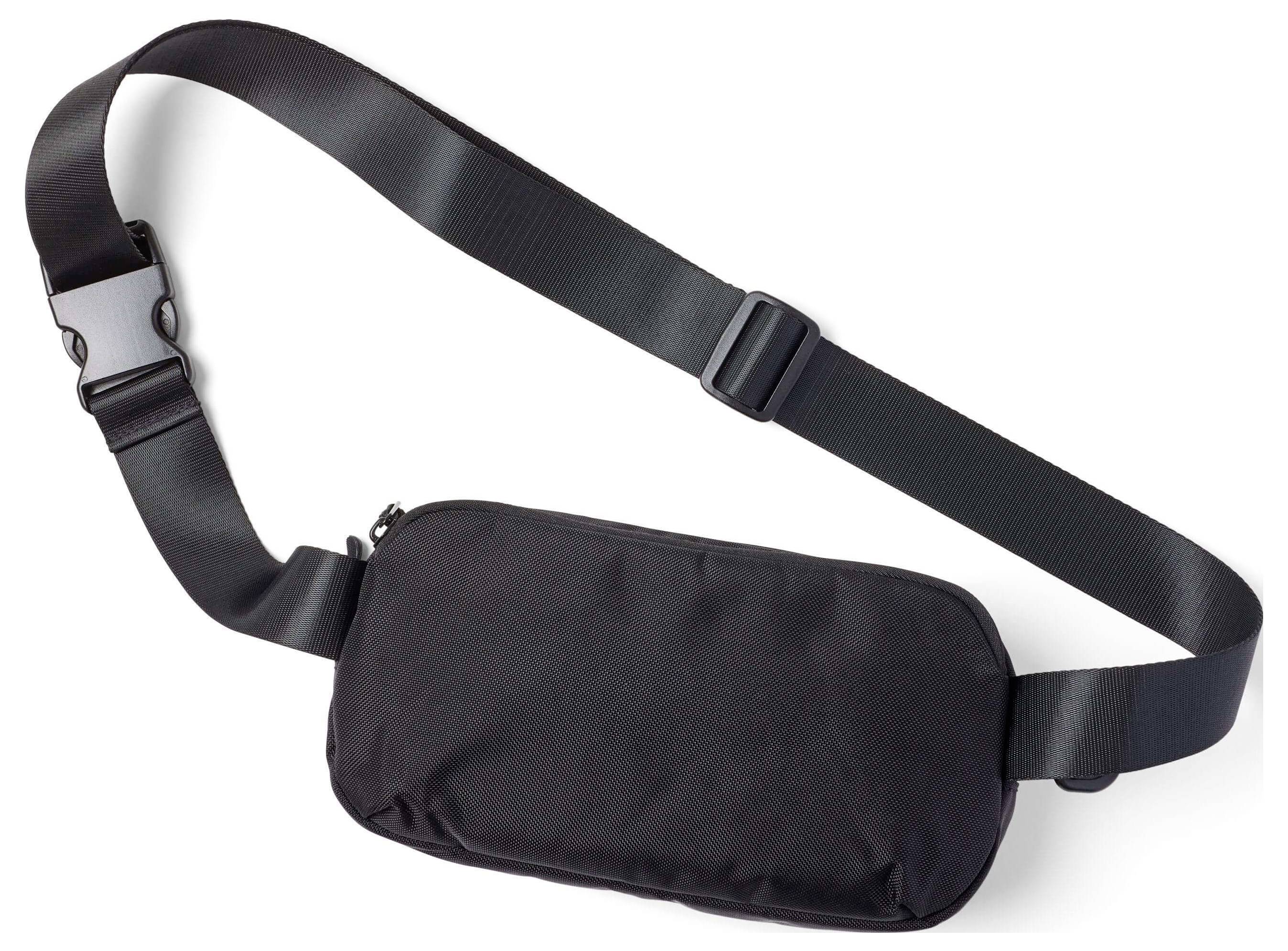 Eine schwarze Umhängetasche mit verstellbarem Nylonriemen und Schnallenverschluss auf weißem Hintergrund.
