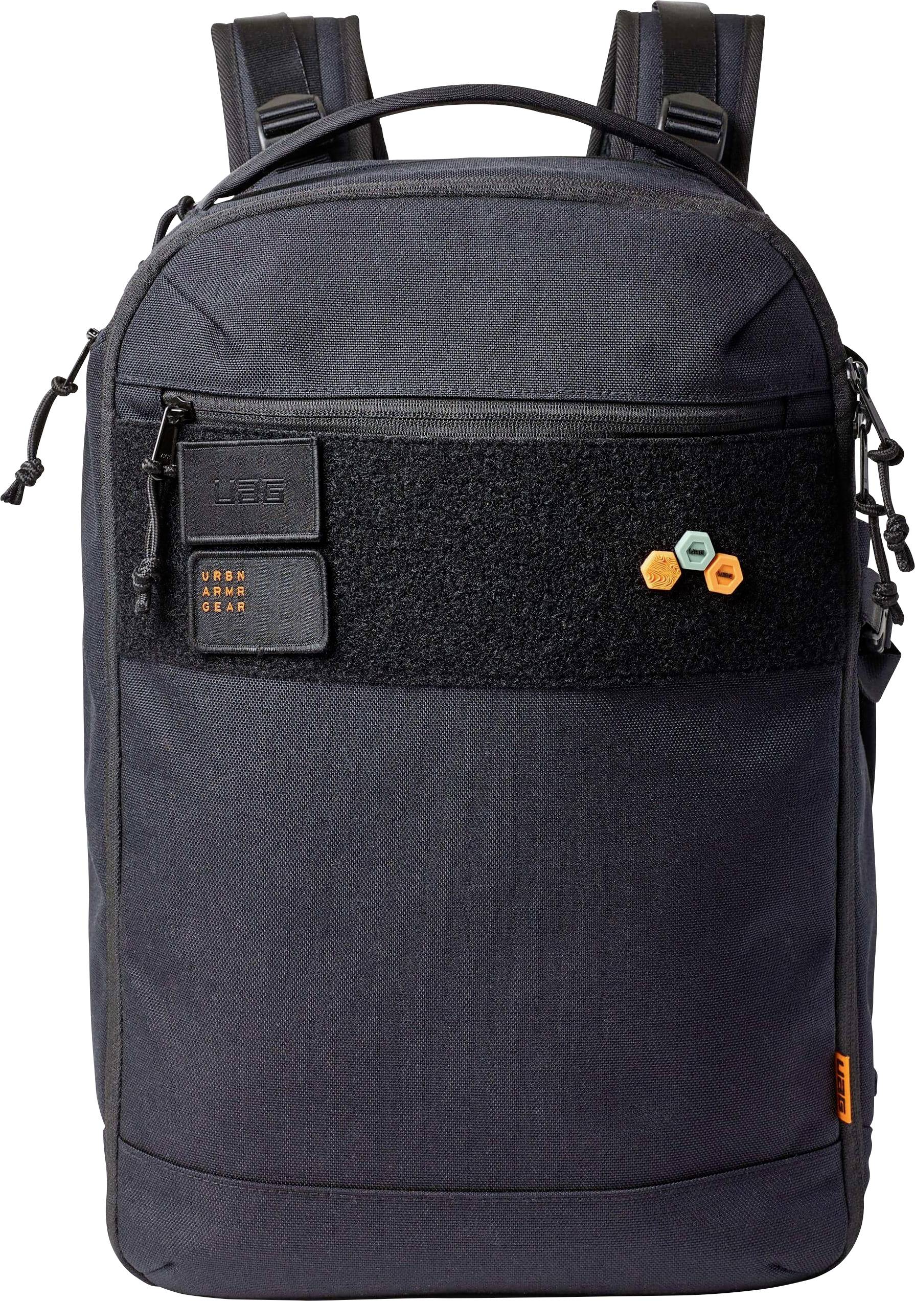 Ein schwarzer Rucksack mit zwei vorderen Taschen und einem gestickten Patch mit zwei Sechsecken und einem kleinen rechteckigen Etikett.