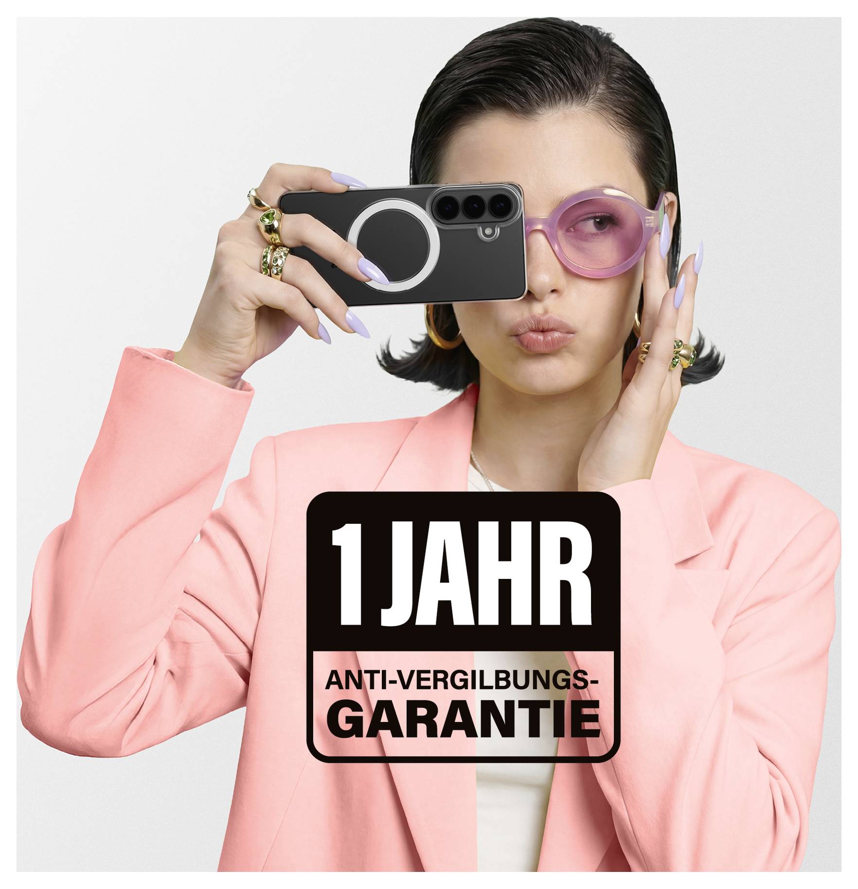 Eine Person in einem rosa Blazer hält ein Telefon mit fettgedrucktem Text „1 Jahr Anti-Vergilbungs-Garantie