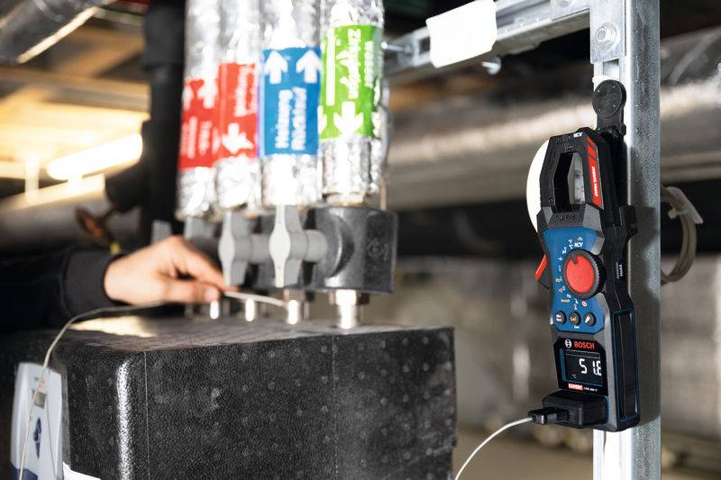 Eine Person verwendet ein Testwerkzeug an Rohren, die in einem mechanischen System mit 