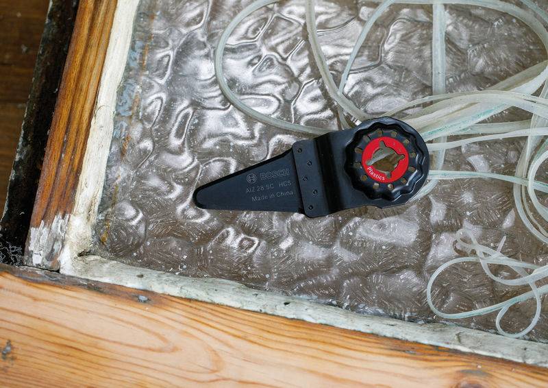 Ein Sensor, der sich in einem Holzrahmen-Behälter befindet, misst die Bodenfeuchtigkeit des Gartens, umgeben von dünnen Rohren, was auf Gartennutzung hinweist.