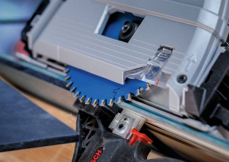 Eine Nahaufnahme eines Kreissägeblattes, das durch Holz schneidet, wobei die Zähne und die präzise Ausrichtung zum Schneiden demonstriert werden. Der Fokus liegt auf dem Blatt und seiner Schärfe.