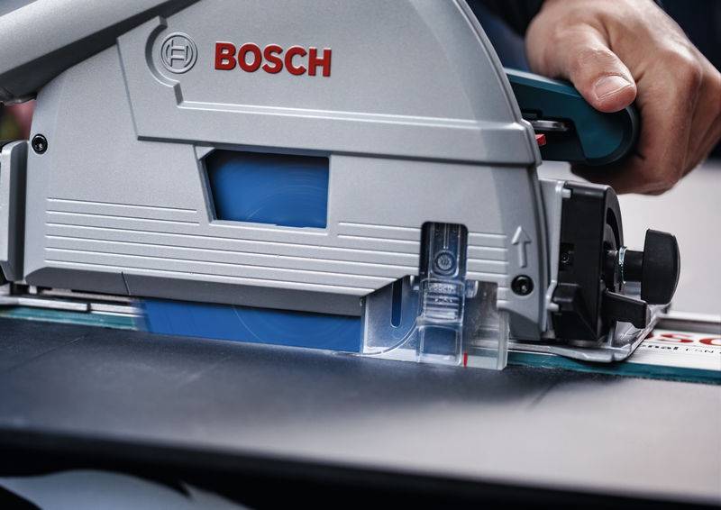 Eine Person benutzt eine Bosch-Elektrosäge zum Schneiden einer Oberfläche und zeigt dabei Konzentration und Präzision.