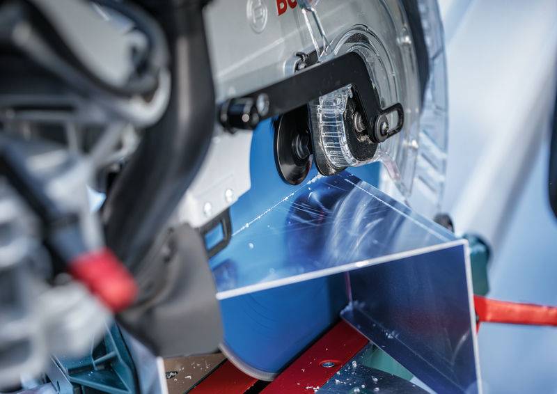 Ein Sägeblatt schneidet durch einen Metallstab in einer Werkstattumgebung und zeigt Präzisionsindustriemaschinen in Aktion.