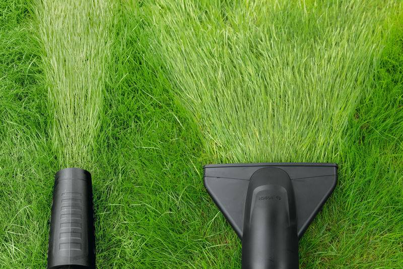 Ein Staubsauger mit zwei Arten von Aufsätzen, die auf Gras gezeigt werden, um den Unterschied in den Luftströmungsmustern für effiziente Blattentfernung zu veranschaulichen.
