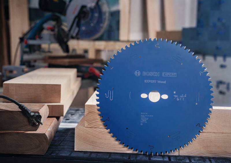Kreissägeblatt zum Holzschneiden wird prominenter auf einer Werkbank ausgestellt, umgeben von Holzbrettern und Werkzeugen in einer Werkstattumgebung.