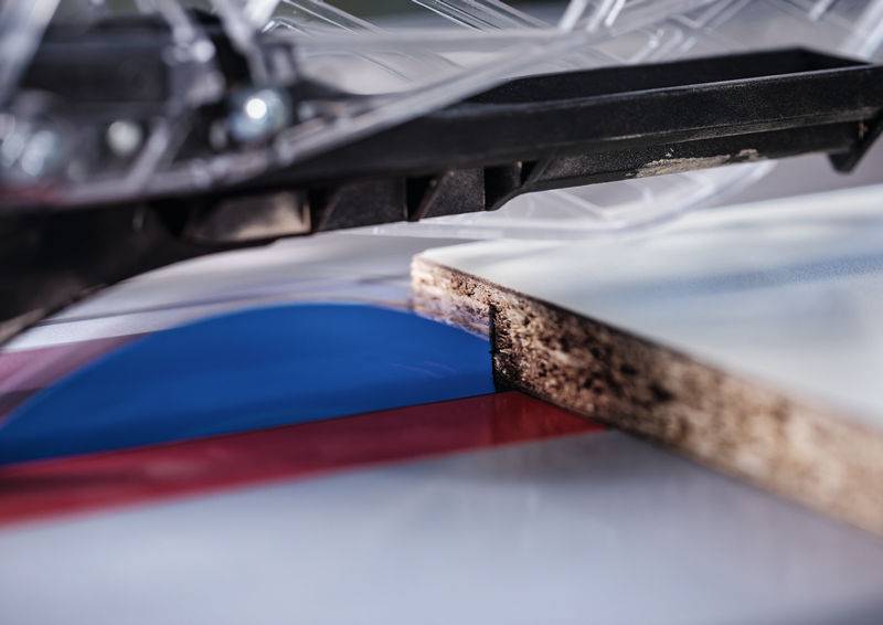 Eine Kreissägeblatt schneidet durch ein Holzbrett auf einer Tischkreissäge und zeigt die Holzbearbeitung mit Präzisionswerkzeugen.