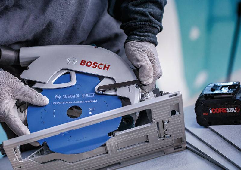 Eine Person mit Handschuhen stellt ein 190-mm-Kreissägeblatt von Bosch Expert ein. Eine CORE18V-Batterie ist auf dem Tisch sichtbar.