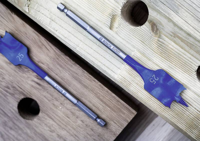 Zwei flache Bohrer liegen auf Holzbrettern. Der größere Bohrer ist mit '25' und 'BOSCH' eingraviert. Sie sind zum Bohren von Löchern in Holz konzipiert.
