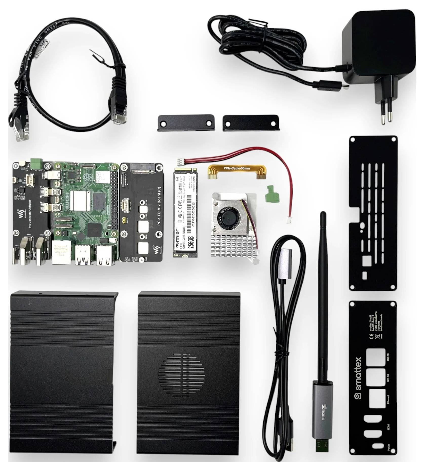 Ein elektronisches DIY-Kit ist ausgelegt, bestehend aus einer Leiterplatte, einem Stromadapter, Kabeln, einem kleinen Bildschirm und Metallgehäusen, was auf eine Montage hindeutet.