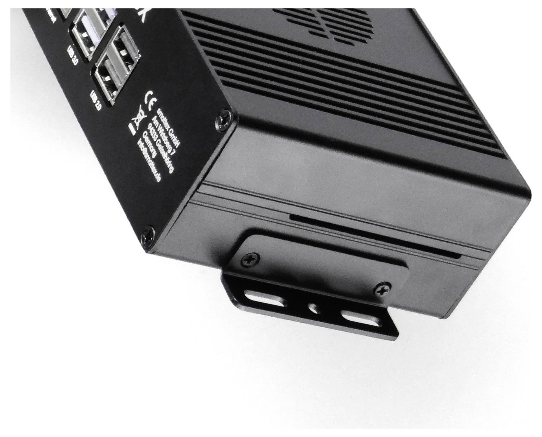 Schwarzes Metallgerät mit mehreren USB-Anschlüssen und Belüftungsschlitzen, auf einer schwarzen Halterung montiert, von der Seite betrachtet.