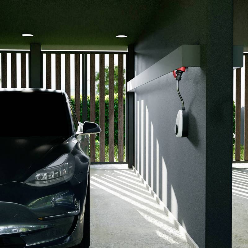 Ein schwarzes Auto steht in einer modernen Garage mit einem an der Wand montierten Elektrofahrzeug-Ladegerät, das Schatten durch Lüftungsschlitze auf den Boden wirft.