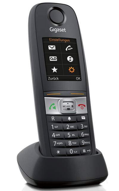 Ein schwarzes schnurloses Telefon mit farbigem Display, auf dem Menüsymbole angezeigt werden. Es ist auf einer Ladestation montiert.