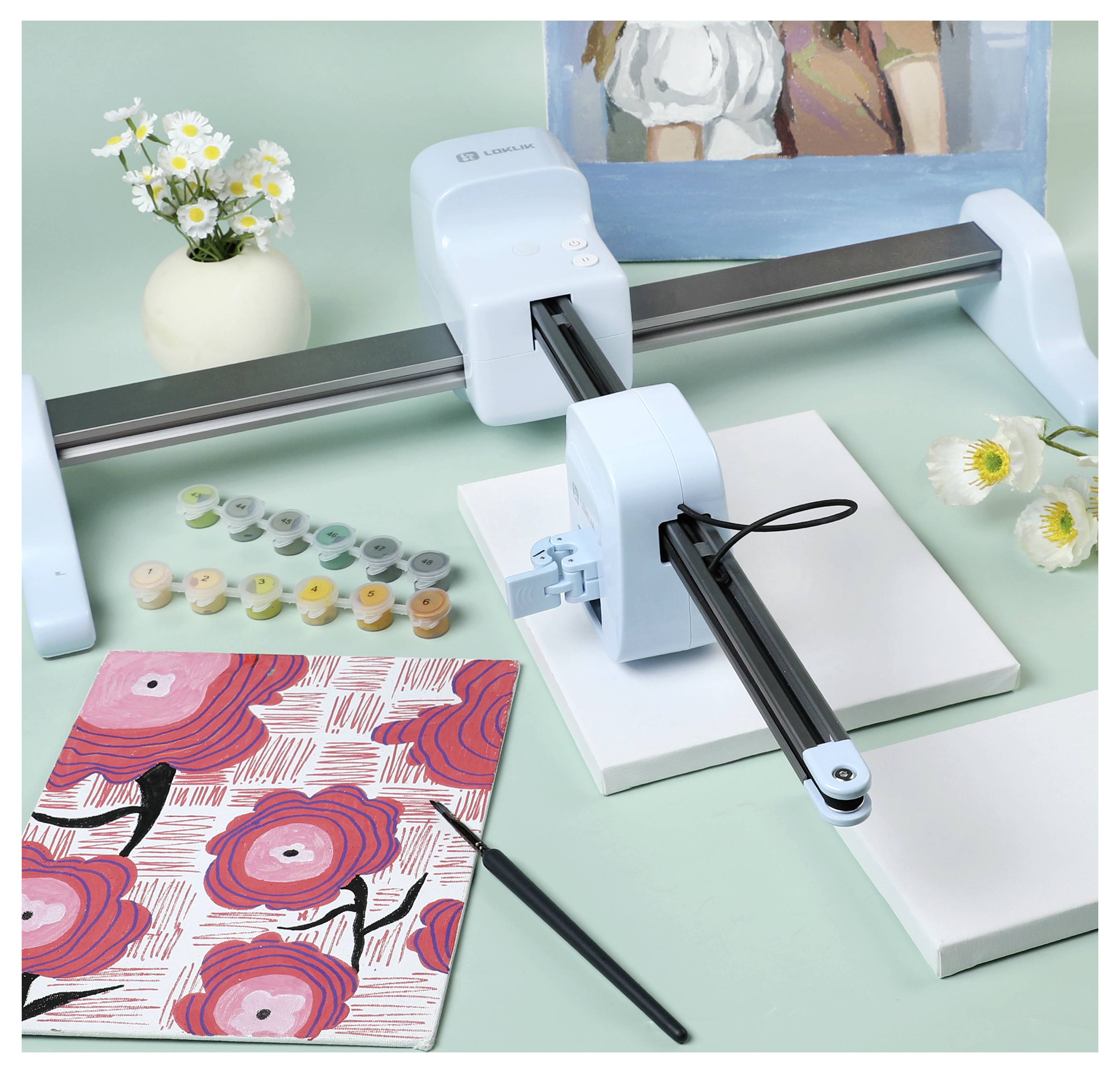 Ein Kunstroboter ist bereit, auf einer leeren Leinwand zu malen, umgeben von Farbdosen, einem gemusterten Notizbuch, einem Pinsel und Blumen.
