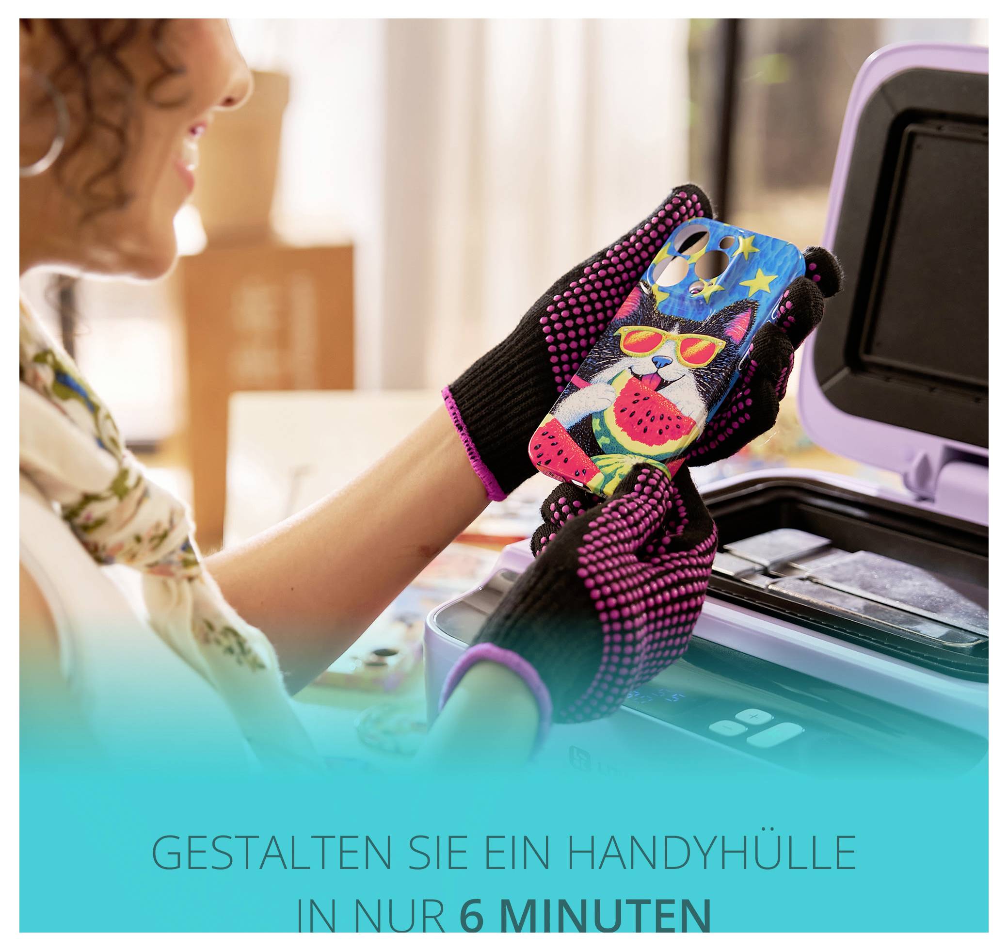 Eine Frau sitzt an einem Tisch, lächelt und trägt Handschuhe, umgeben von farbigen Nadeln und einer violetten Maschine. Eine Topfpflanze ist im Hintergrund.