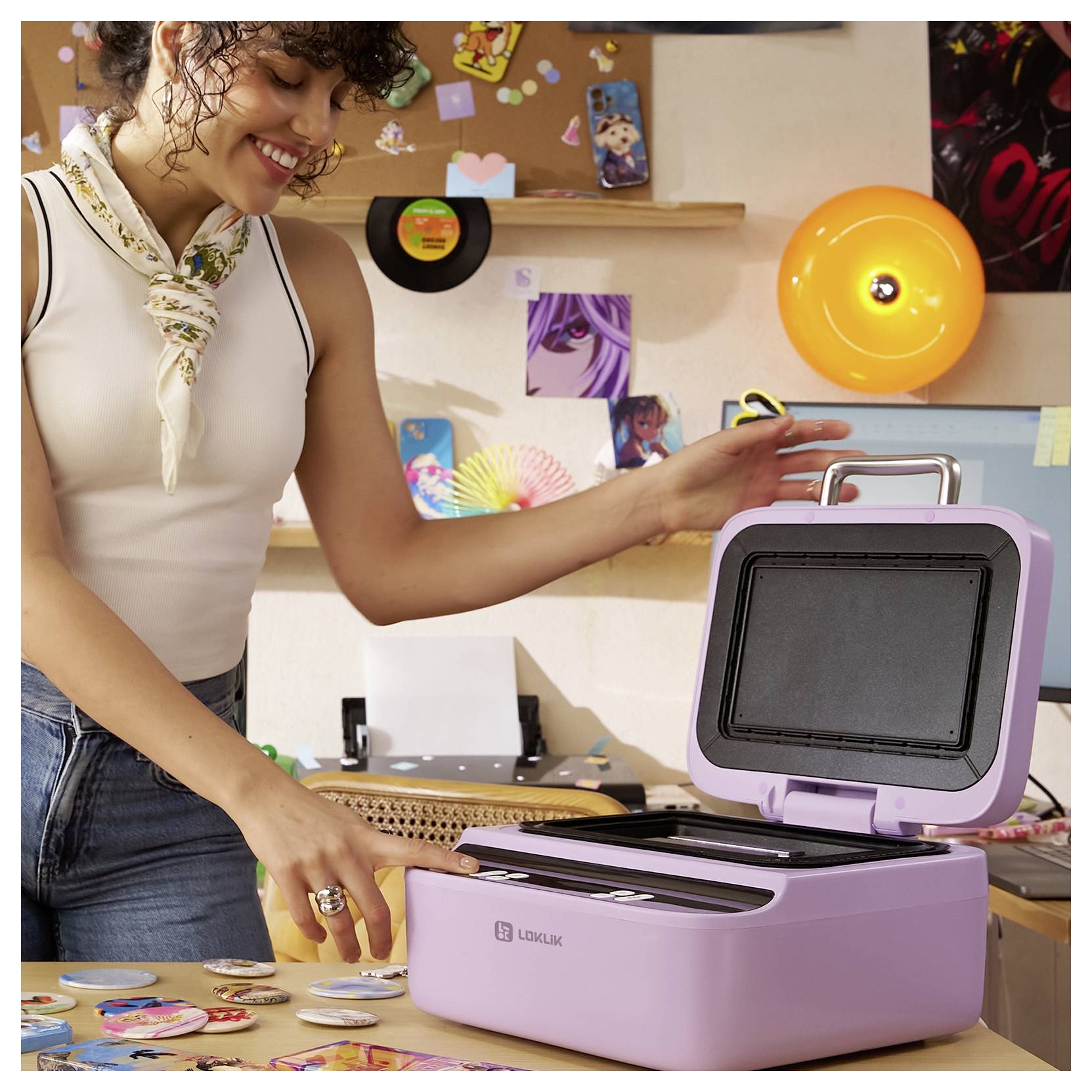 Eine Person, die lächelt, während sie eine lila LemoLux-Maschine benutzt, um Aufkleber in einem farbenfrohen, künstlerischen Arbeitsbereich zu erstellen.