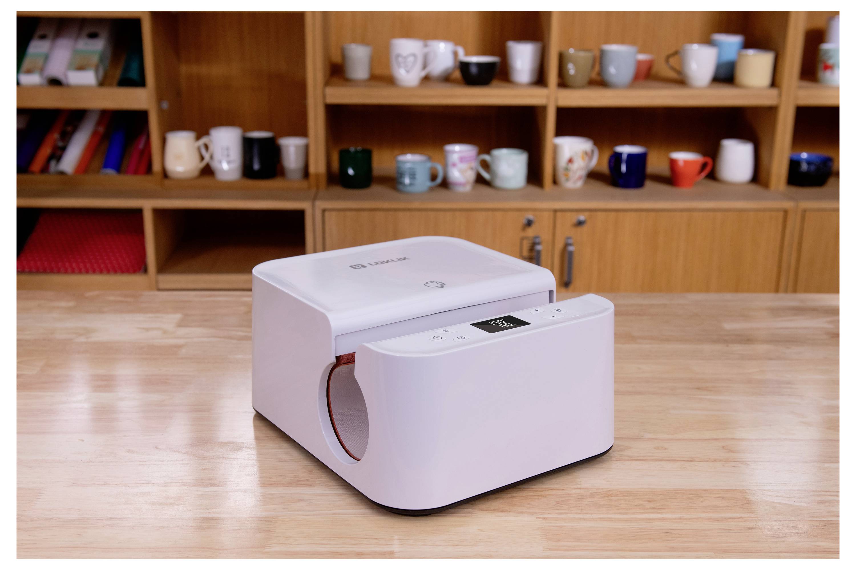 Ein weißes Küchengerät auf einer Holzarbeitsplatte, mit Regalen voller bunter Tassen im Hintergrund.