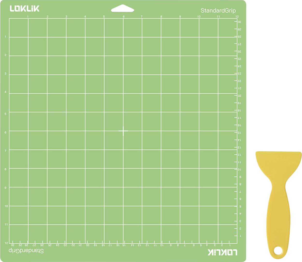 Eine grüne Schneidematte mit Rastermuster neben einem gelben Kunststoffschaber, beide mit der Aufschrift 