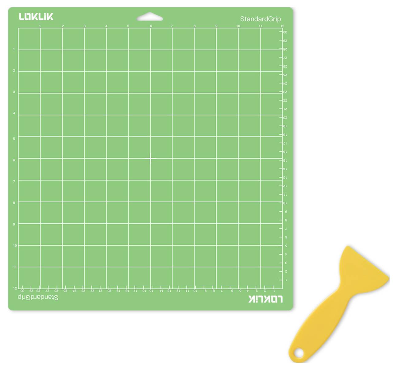 Eine grüne Schneidematte mit Rastermuster neben einem gelben Schabwerkzeug auf weißem Hintergrund.