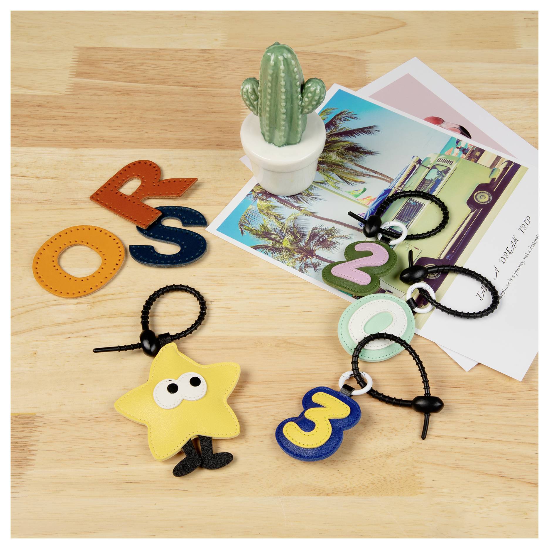 Holzoberfläche mit farbenfrohen Lederanhängern in Form der Buchstaben „O