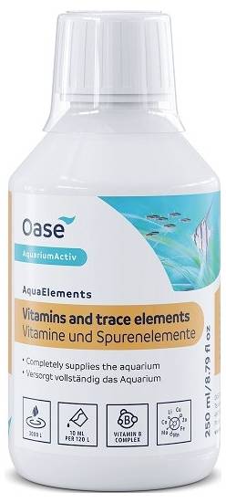 Bottle of aquarium supplements labeled 'Vitamins and trace elements' in both English and German, features nutrient symbols.