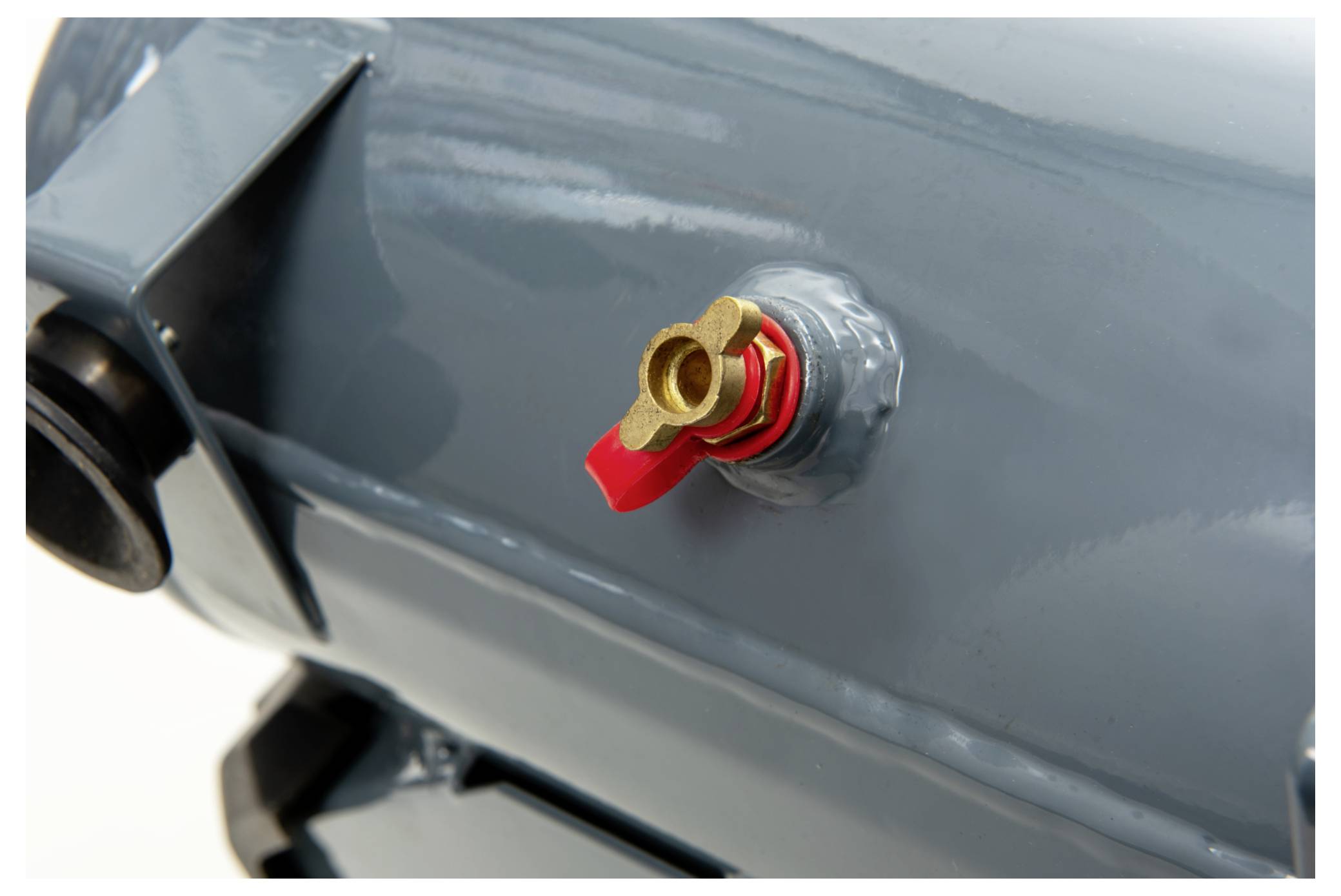 Ein Nahaufnahmebild eines silbernen Drucklufttanks mit einem roten Metallventil. Das Ventil ist auf der Oberfläche des Tanks montiert.