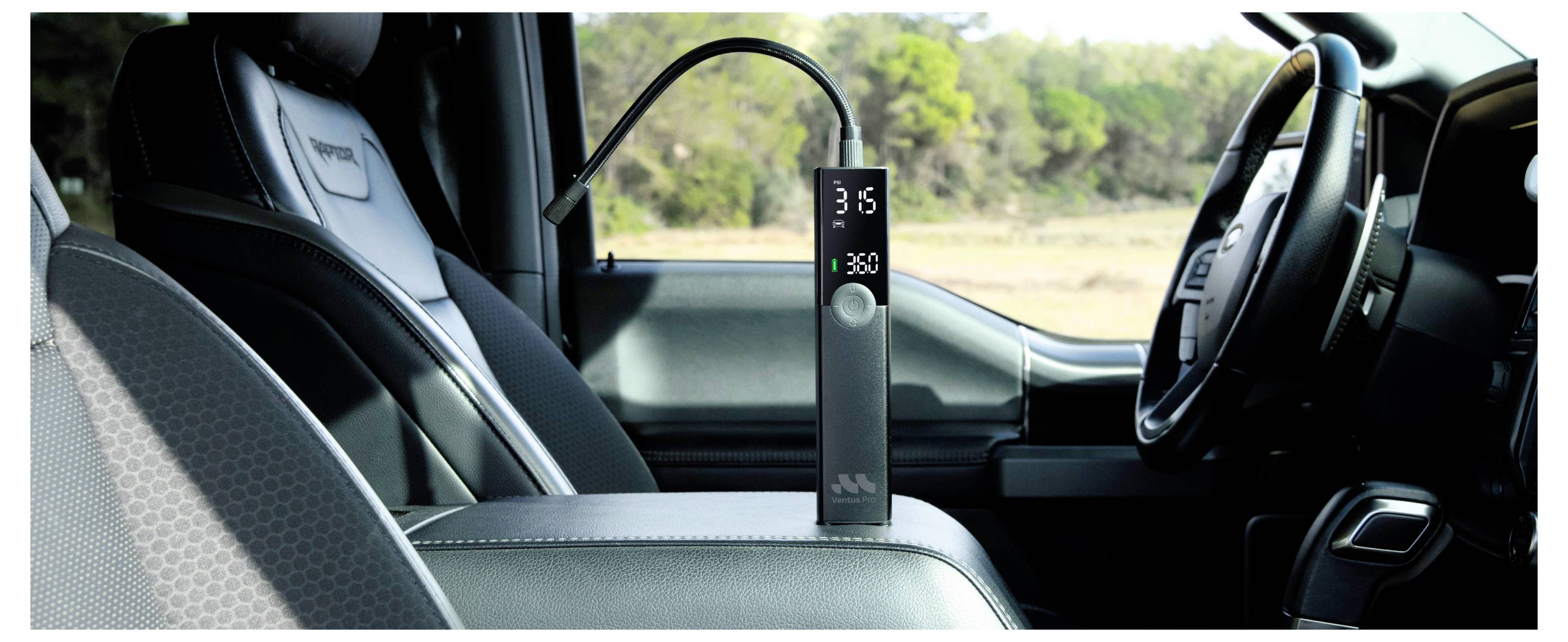 Ein tragbarer Luftkompressor wird auf dem Vordersitz eines Fahrzeugs angezeigt. Das digitale Display zeigt die Druckeinstellung. Das Fahrzeuginnere ist sichtbar.