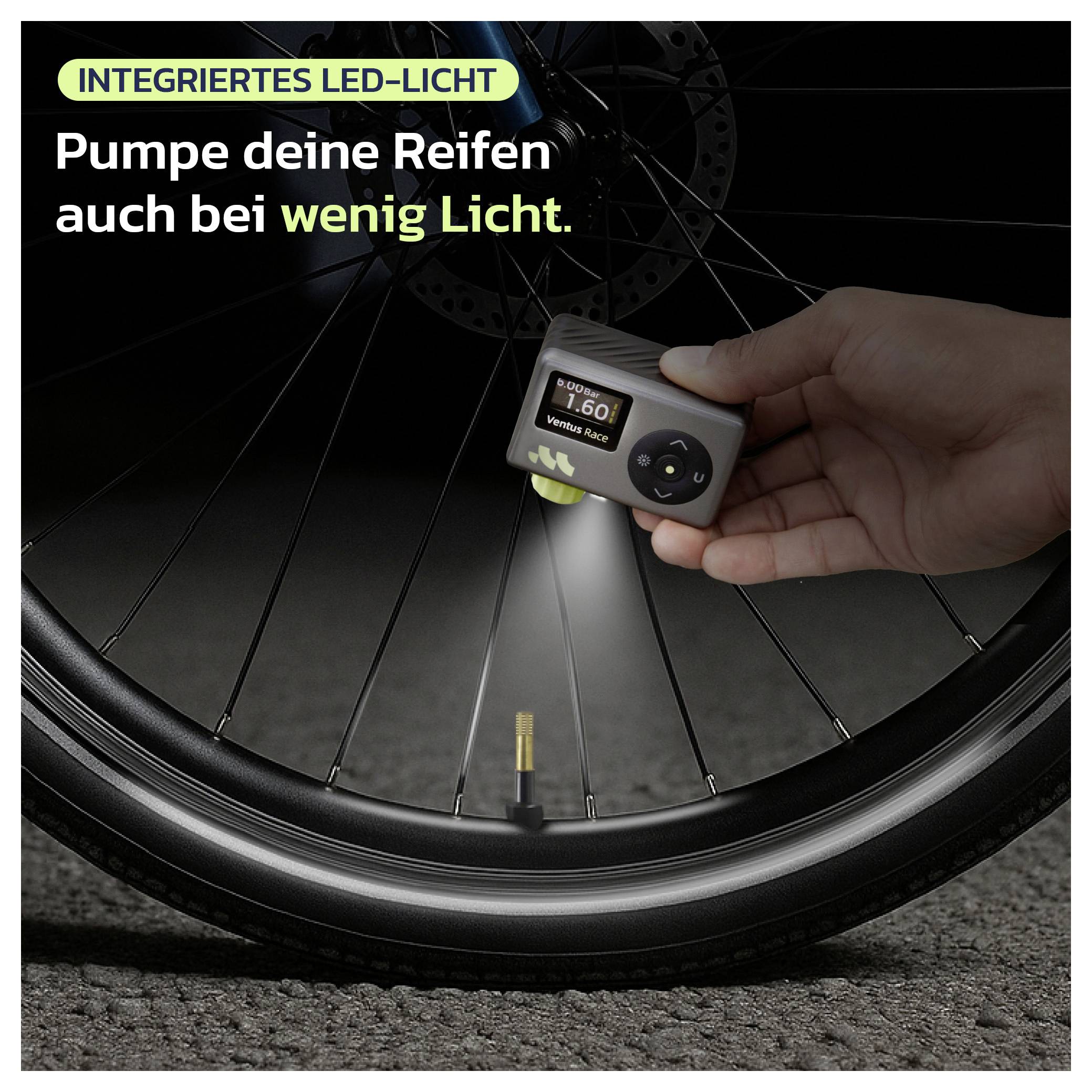 Hand, die eine Fahrradpumpe mit integrierter LED-Leuchte hält, die ein Reifenventil beleuchtet; der Text besagt „INTEGRIERTES LED-LICHT
