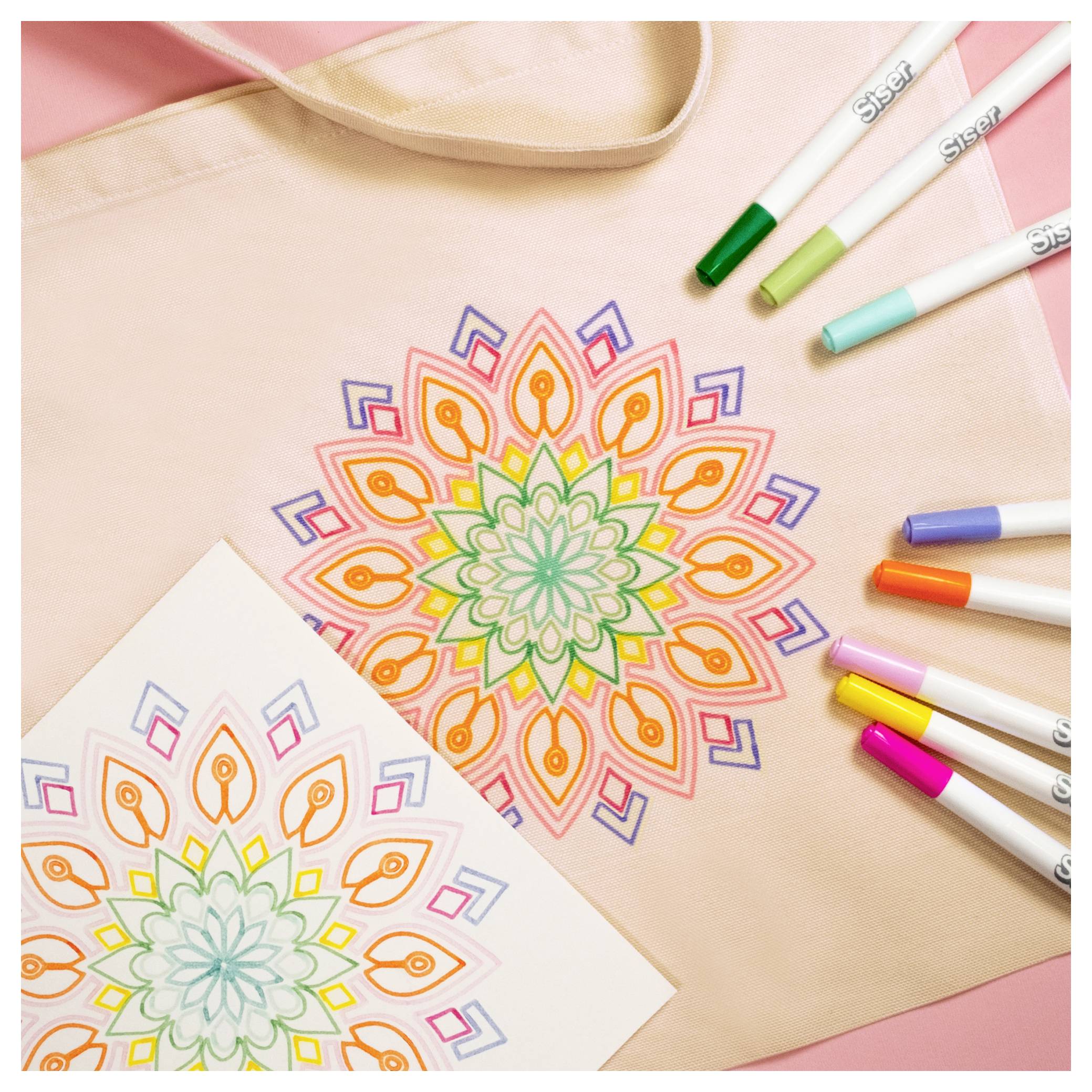 Buntes Mandala-Muster mit Markern auf einer Stoff-Tragetasche und einem Blatt Papier, das ein DIY-Bastelprojekt zeigt.
