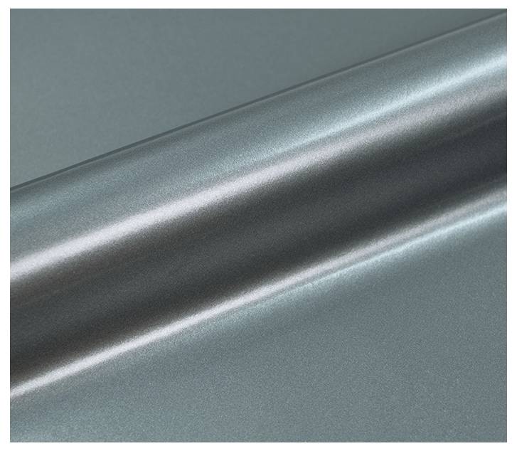 Eine Nahaufnahme einer metallischen Oberfläche mit einer glatten, reflektierenden Textur und einem subtilen graugrünen Farbton. Die Beleuchtung hebt den Glanz der Oberfläche hervor.