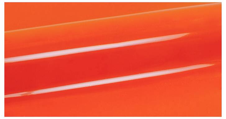 Nahaufnahme einer glänzenden orangefarbenen Oberfläche mit zwei parallelen weißen Glanzlichtern, die diagonal darüber verlaufen.