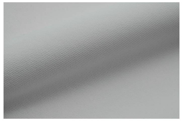 Ein Nahaufnahmebild einer weißen strukturierten Oberfläche, möglicherweise ein aufgerolltes Stück Stoff oder Papier, mit sichtbaren Körnung- und Schattendetails.
