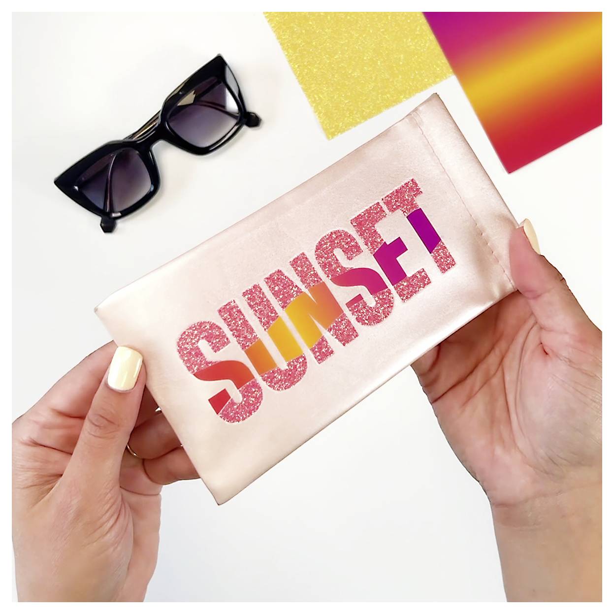 Hände halten einen glänzenden Beutel mit der Aufschrift „SUNSET