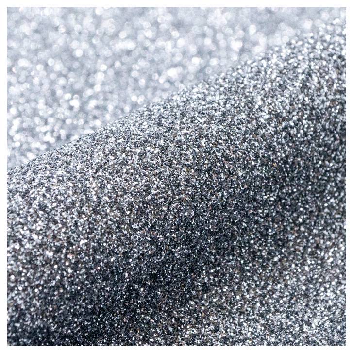 Nahaufnahme von silbernem Glitterstoff, die seine funkelnde Textur und Schimmereffekt zeigt.
