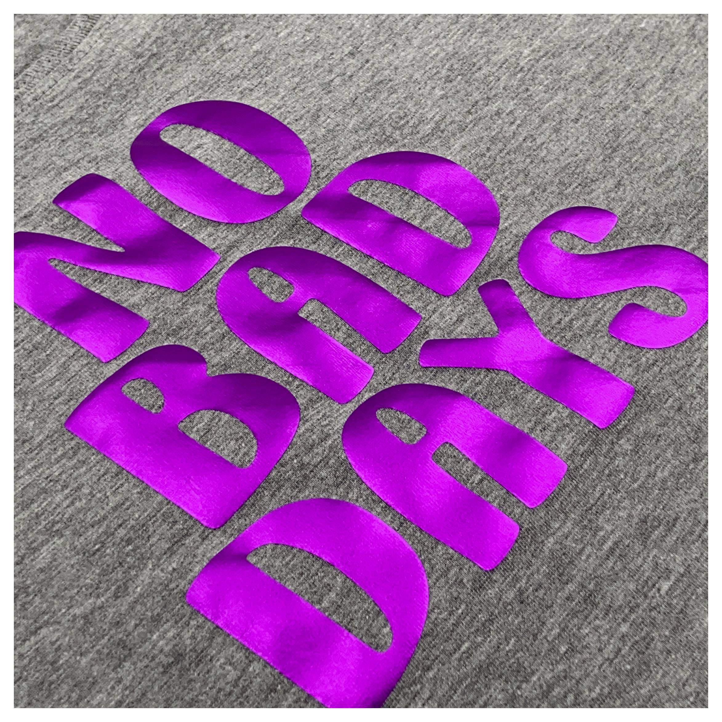 Das Bild zeigt einen grauen Stoff mit großem, kühnem, violettem Text, auf dem „NO BAD DAYS