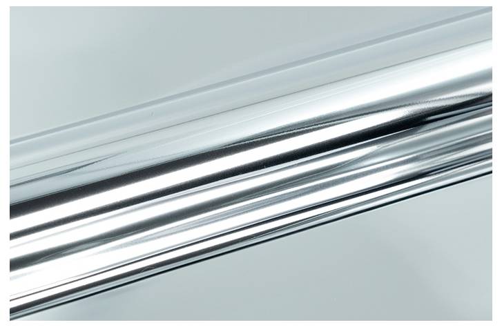 Eine Nahaufnahme einer glänzenden, reflektierenden metallischen Oberfläche, die glatte Texturen und Lichtreflexionen zeigt.