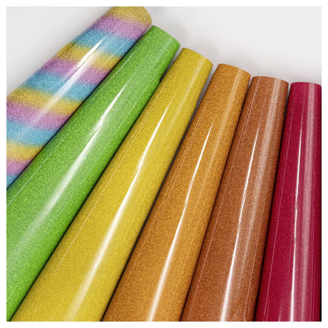 Bunte, glitzernde Rollen Geschenkpapier in diagonaler Anordnung angeordnet, mit Streifen und verschiedenen Vollfarben: Grün, Gelb, Orange, Rosa.