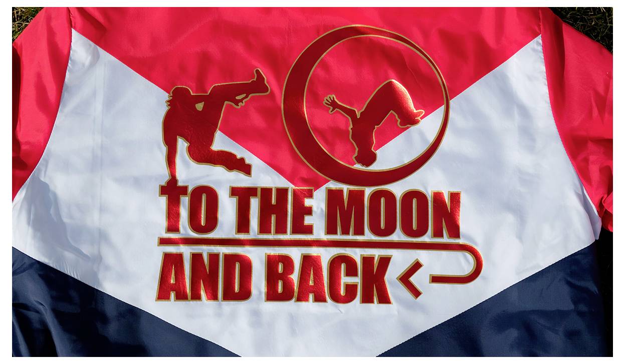 Eine rot-weiß-blaue Jacke mit dem Text „ZUM MOND UND ZURÜCK