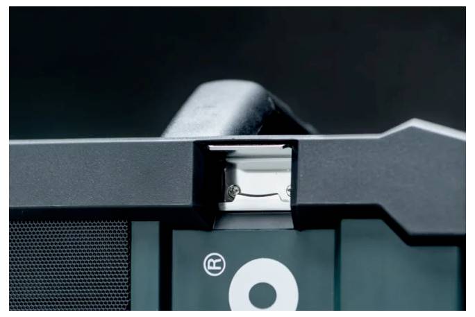 Eine Nahaufnahme eines Geräts mit einem Anschlussport in der Mitte, umgeben von einem schwarzen Gehäuse mit einem teilweise sichtbaren 