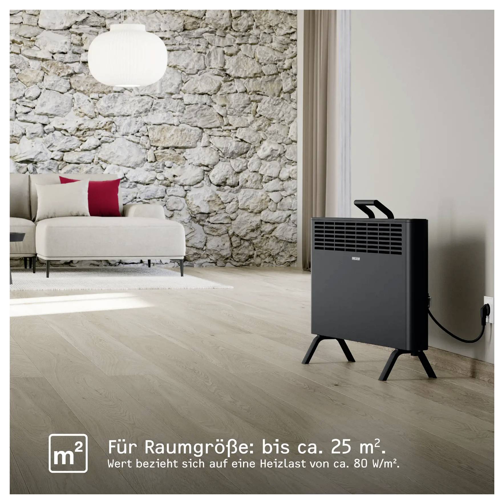 Ein Wohnzimmer mit einer Steinwand, beigem Sofa, roten Kissen und einem schwarzen Elektroheizer in der Ecke. Der Text lautet „Für Raumgröße: bis ca. 25 m²