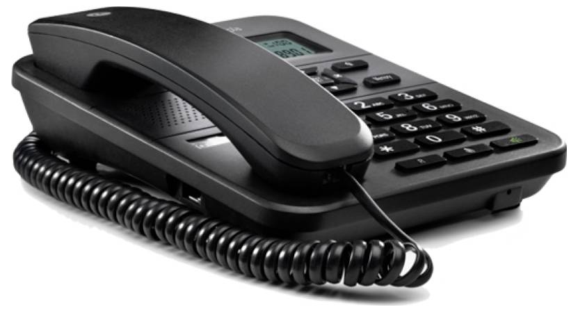 Ein schwarzes schnurgebundenes Bürotelefon mit numerischer Tastatur, Anzeigebildschirm und spiralförmiger Hörerleitung, das auf einer ebenen Oberfläche ruht.