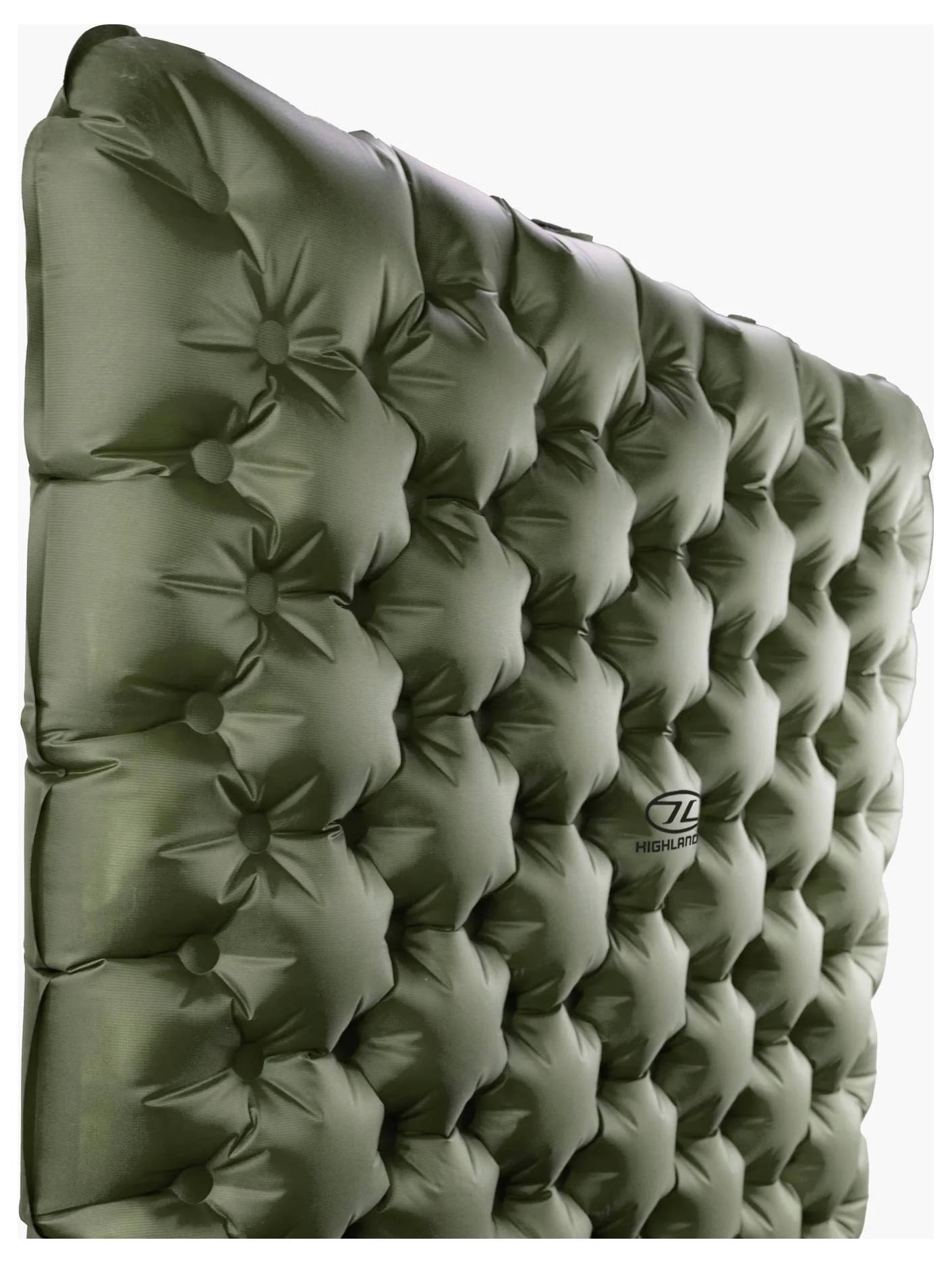 Eine grüne, aufgeblasene Campingmatte mit gestepptem Muster und einem kleinen Logo in der Mitte, von der Seite betrachtet.