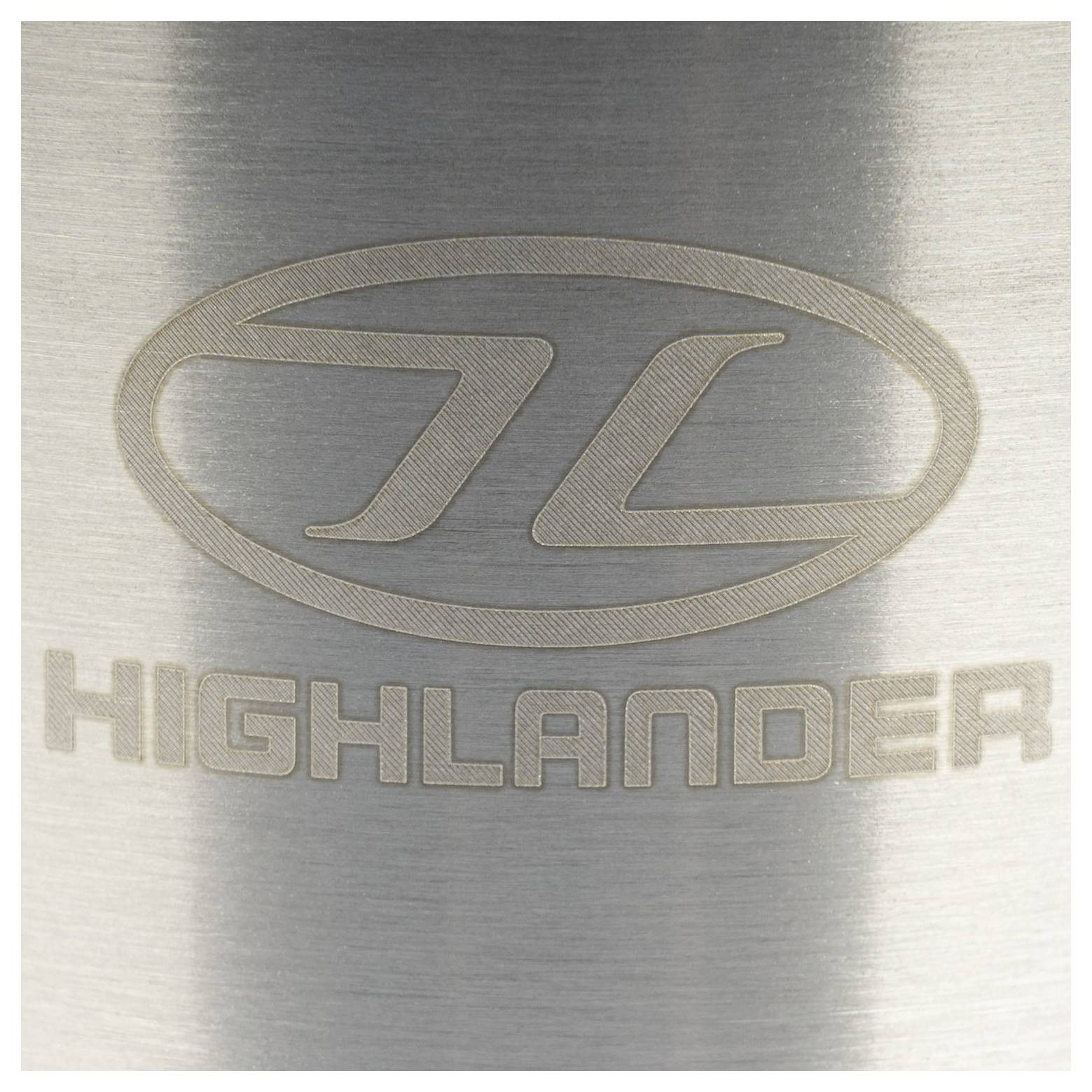 Eine metallische Oberfläche zeigt ein eingraviertes Logo mit einer ovalen Form über dem Wort „HIGHLANDER