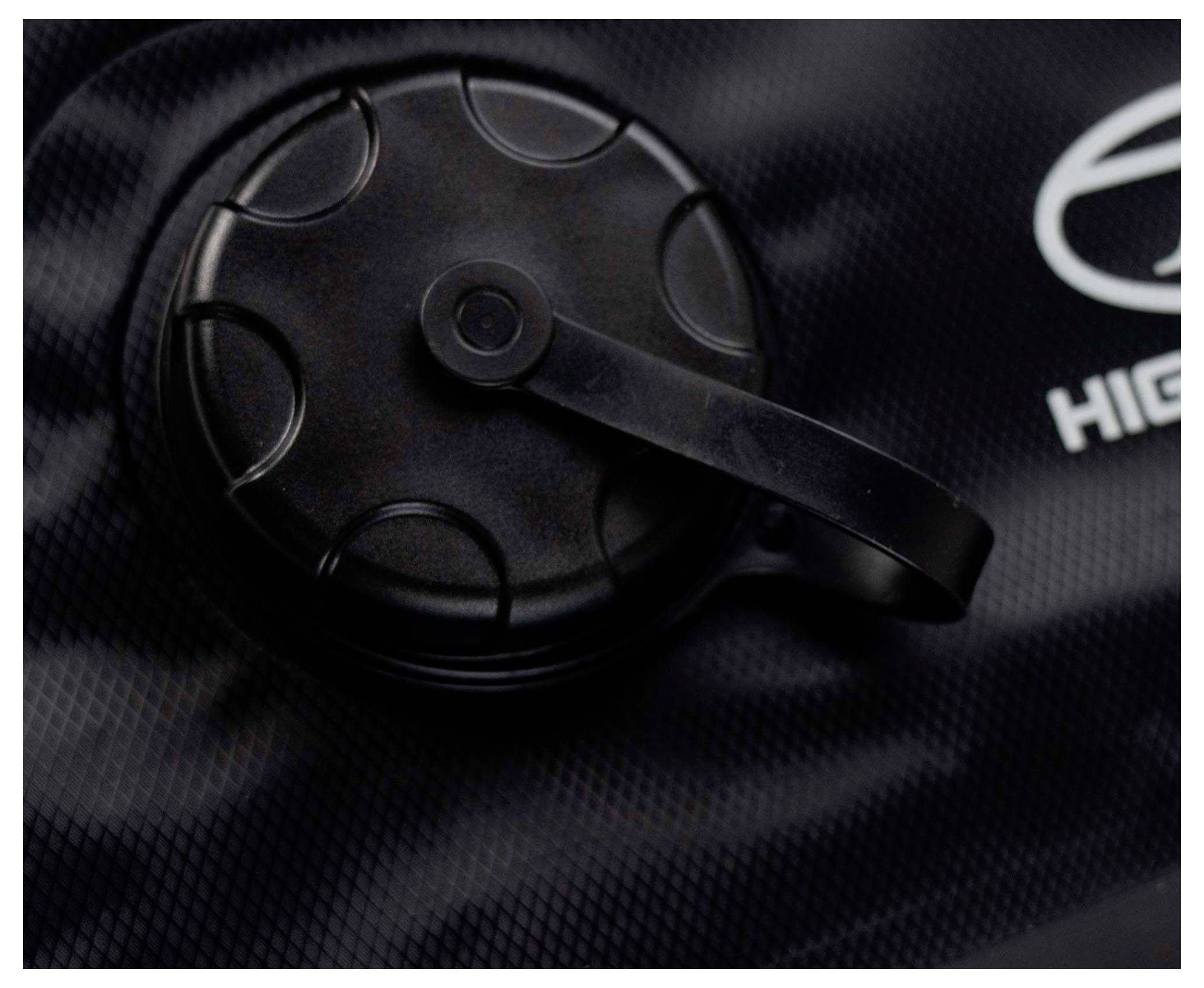 Schwarze strukturierte Oberfläche mit einer runden, gerillten Kappe und einem Seitengriff. Teilweise sichtbares Logo auf der rechten Seite.