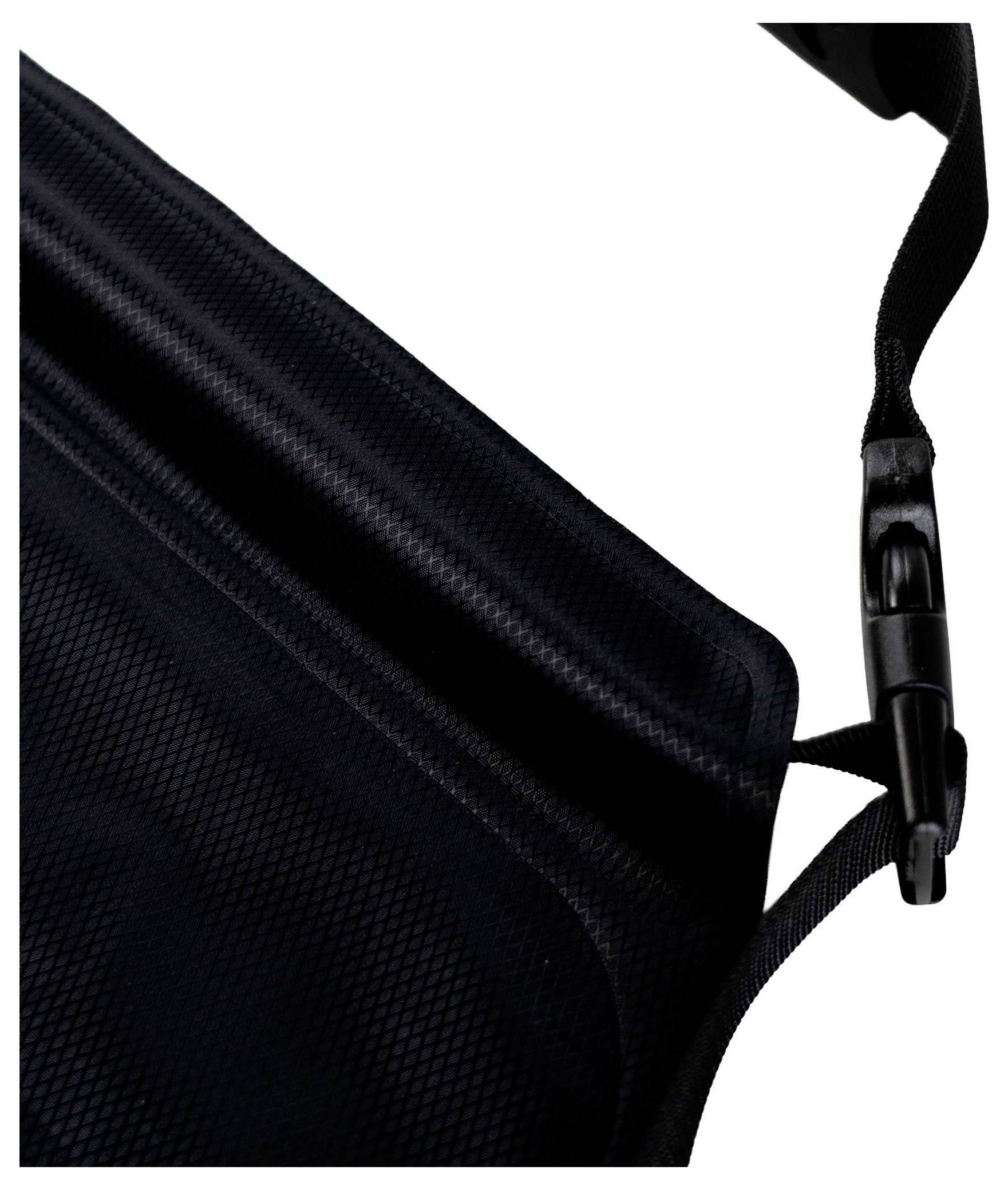 Nahaufnahme eines schwarzen Stoffbandes mit einer Kunststoffschnalle, teilweise gegen einen weißen Hintergrund sichtbar.