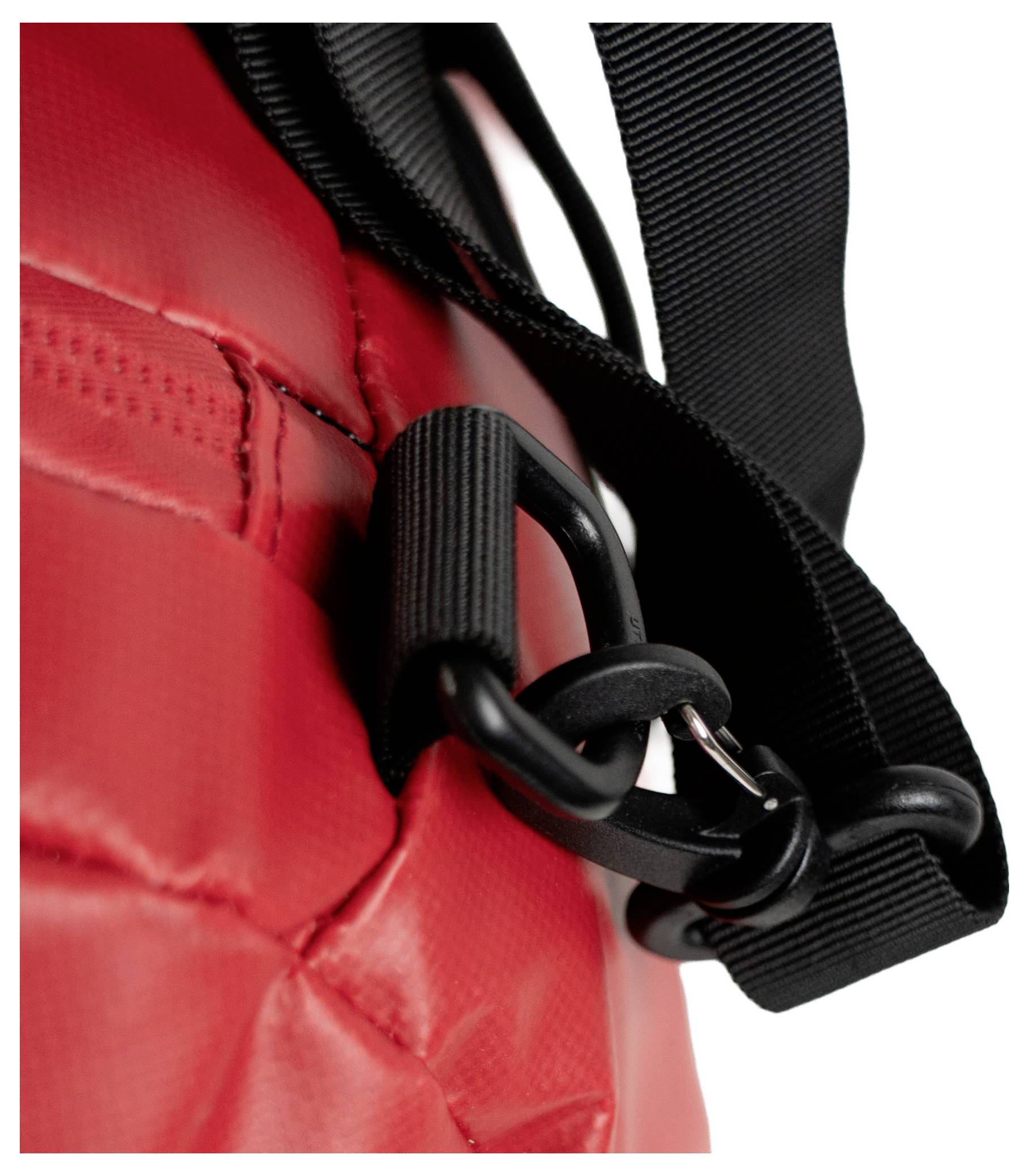 Nahaufnahme eines roten gesteppten Materials mit einem schwarzen Riemen, der an einer Schlaufe befestigt ist, wahrscheinlich Teil einer Tasche oder eines Rucksacks.