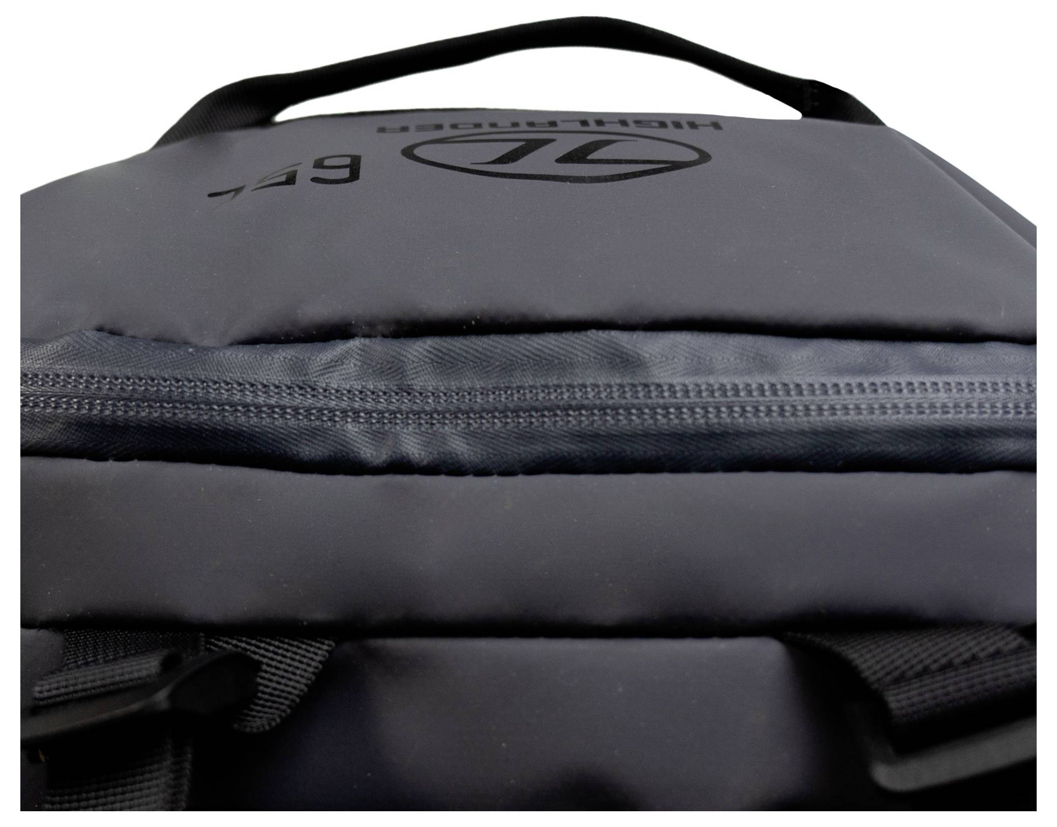 Eine Nahaufnahme eines schwarzen Rucksacks, die einen Reißverschluss und einen Teil des Griffs zeigt, mit einem sichtbaren Logo auf dem Stoff.