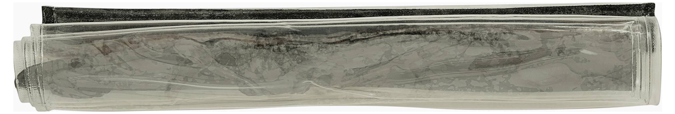 Eine transparente Rolle enthält ein schlangenartiges schwarzgraues Objekt, möglicherweise eine Zeichnung oder Skulptur, das in einem zylindrischen Rohr aufgerollt ist.