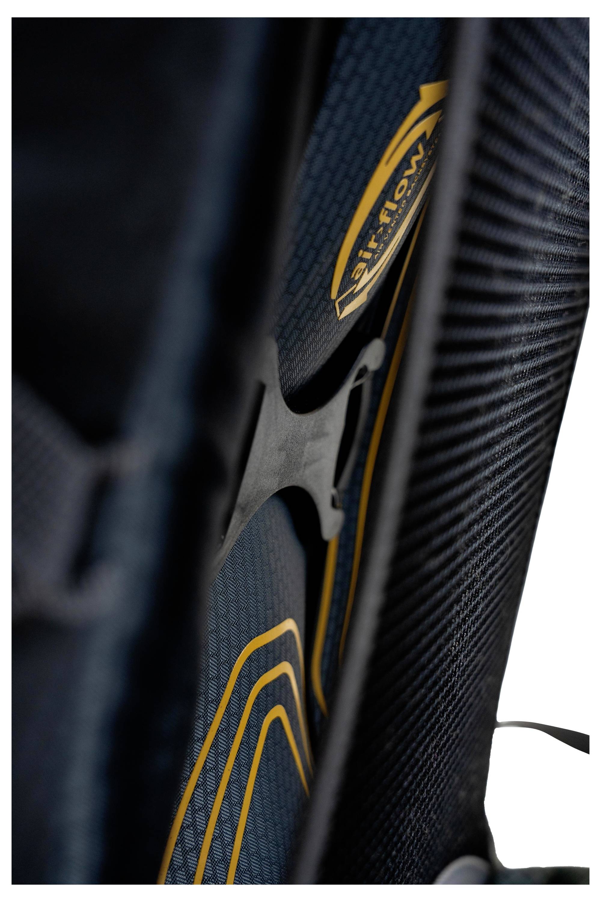 Eine Nahaufnahme eines strukturierten Rucksacks mit diagonalen orangefarbenen Linien und dem sichtbaren Wort 