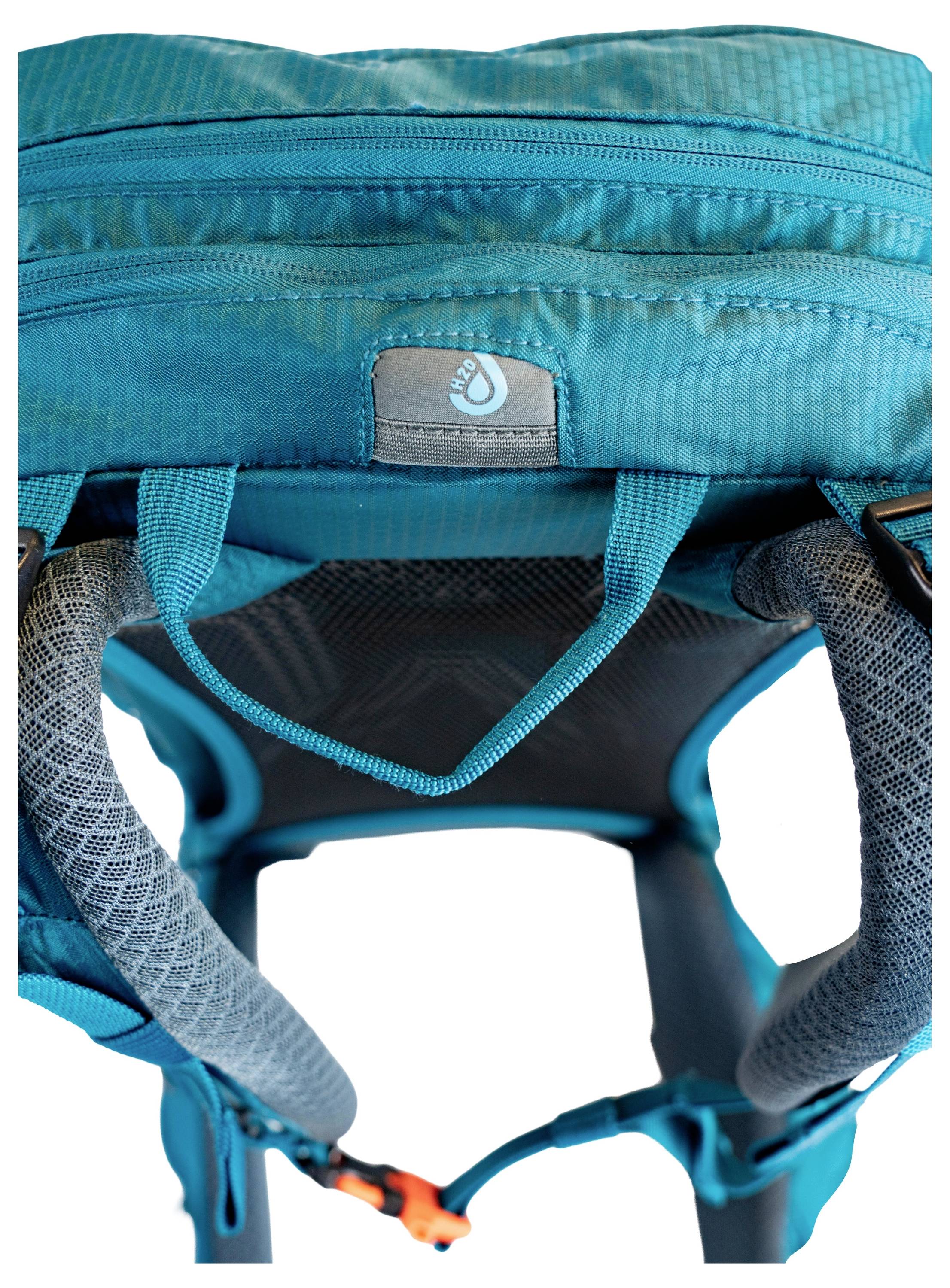 Eine Nahaufnahme eines türkisfarbenen Wanderrucksacks mit verstellbaren Schultergurten und einem sichtbaren Logo-Emblem oben.